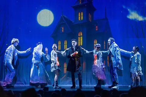 La troupe devant la maison hantée, sous la pleine lune